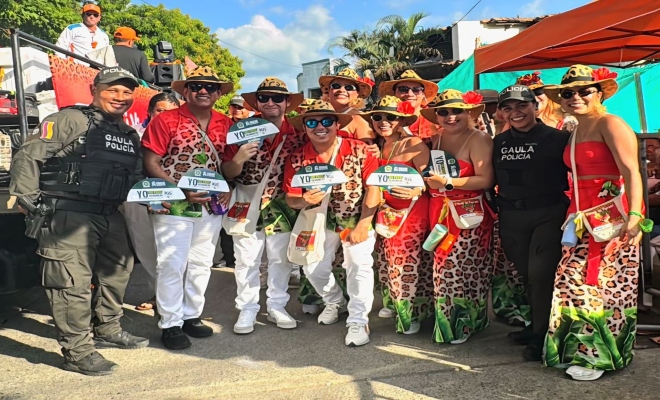 dos uniformados con un grupo de bailarines de  comparsas  en la feria nacional de la ganadería 
