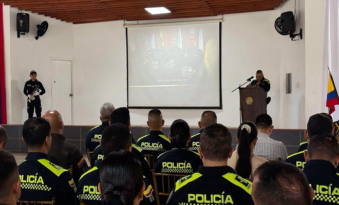 Bohío de la escuela con personal uniformado en un auditorio y asistentes