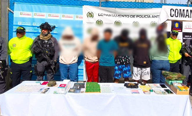 6 capturados por el delito de tr&aacute;fico de estupefacientes en Antioquia, policias y ejercito custodiandolos, elementos incautados sobre una mesa.