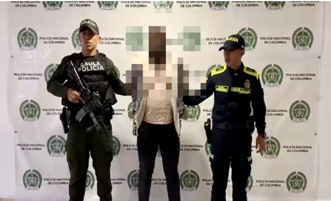 un policía a la derecha, un capturado en la mitad y, un policia a la izquierda