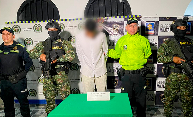 Persona capturada escoltado por uniformado de la seccional de investigación criminal y ejercito nacional de Colombia