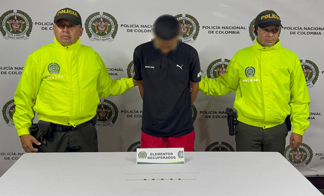 Dos policías de la sijin con un capturado por hurto y dos cadenas de oro sobre la mesa las cuales fueron recuperadas