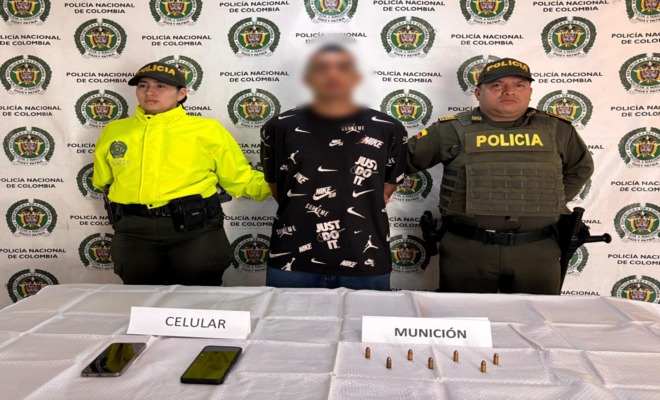 Dos polic&iacute;as de la SIJIN custodian a un capturado y elementos incautado