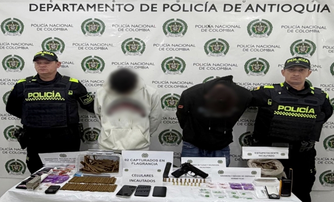 Dos policías custodian a dos capturados, una arma y estupefacientes incautados