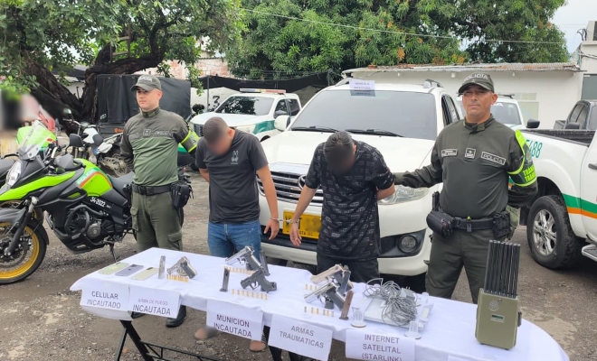 Dos policias custodian a dos sujetos