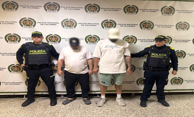 Dos hombres capturados acompa&ntilde;ados por dos policias