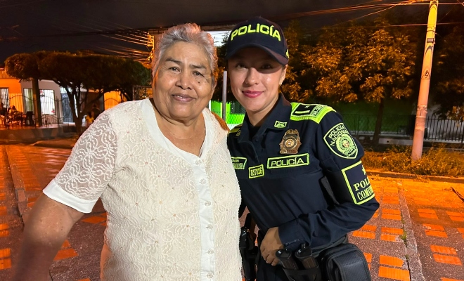 Funcionaria policial junto a una adulto mayor sonriendo