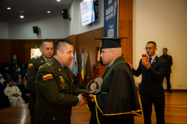 Director de educación policial saludando a un estudiante destacado de la Maestría en Gestión de la Seguridad