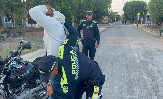 dos uniformados de la polic&iacute;a nacional realizando controles registro a personas en v&iacute;a publica 