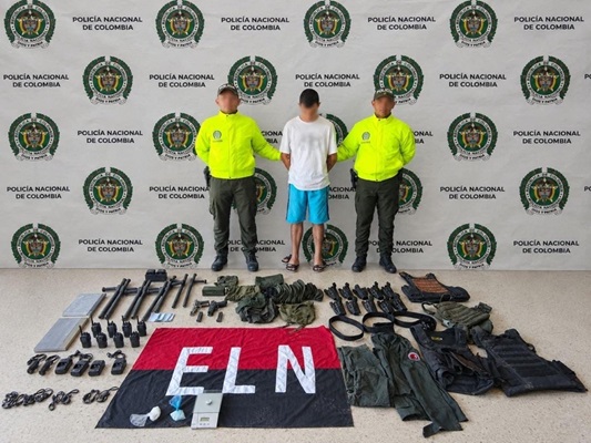 Dos polic&iacute;as custodiando un capturado y material incautado