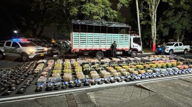 Dos uniformados de la Polic&iacute;a Nacional junto a aproximadamente dos toneladas de marihuana incautadas en un contundente golpe al narcotr&aacute;fico.