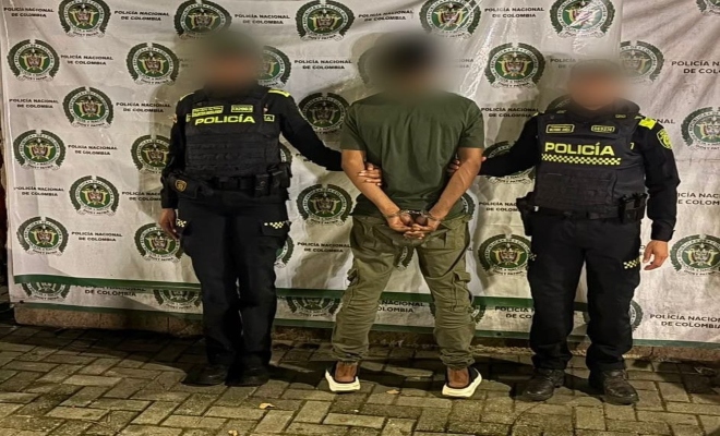 Dos policías con una persona capturada por el delito de tráfico, fabricación o porte de estupefacientes  