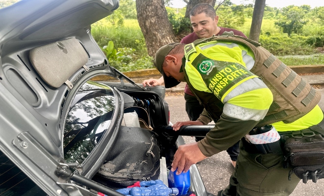 un uniformado realizando registro control en vehículos para este puente festivo 
