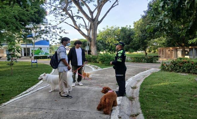 un policía brindando recomendaciones de seguridad a dos ciudadanos 