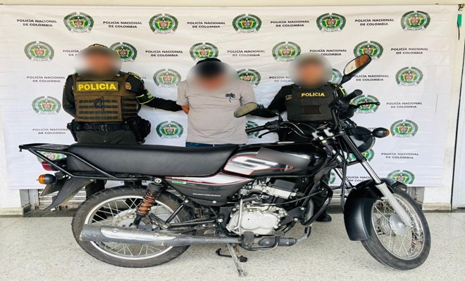 Polic&iacute;as con persona capturada junto a la moto recuperada