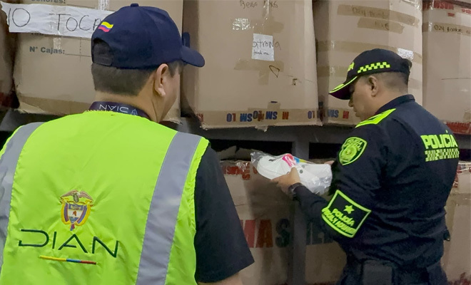 Funcionarios de la policía fiscal y aduanera y la dian inspeccionan mercancía ilegal hallada en varias cajas