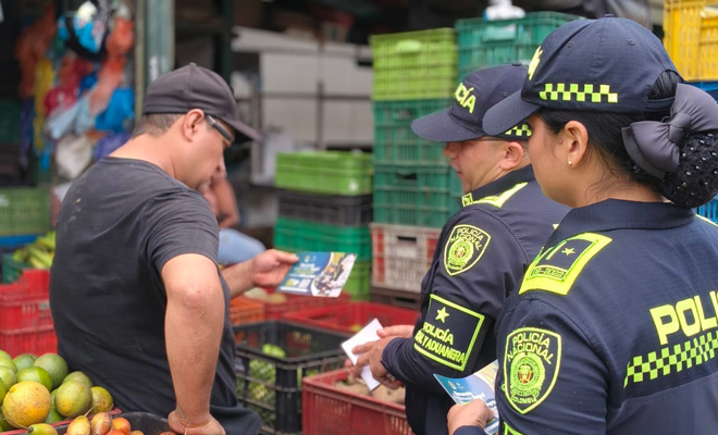 Funcionarios de la policía fiscal y aduanera entregan información a comerciantes sobre como contrarrestar el contrabando durante el receso escolar
