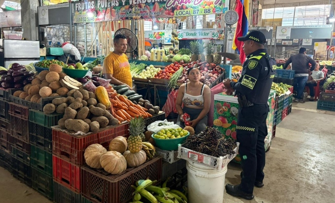 Funcionario policial junto a dos ciudadanos brindándoles recomendaciones 
