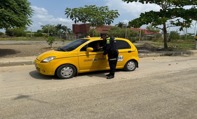 Un policía saludando a un taxista en controles 