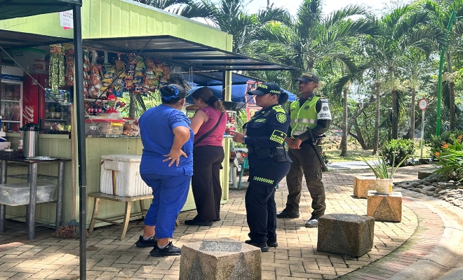 dos uniformados hablando con dos ciudadanas sobre campañas de prevención en el parque principal de la ciudad  de montería  
