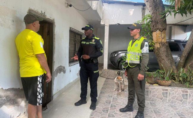 Dos funcionarios policiales junto a un ciudadano brindando recomendaciones en actividades de puerta a puerta