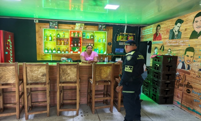 un uniformado de la polic&iacute;a nacional con una  ciudadana en establecimiento abierto al publico 