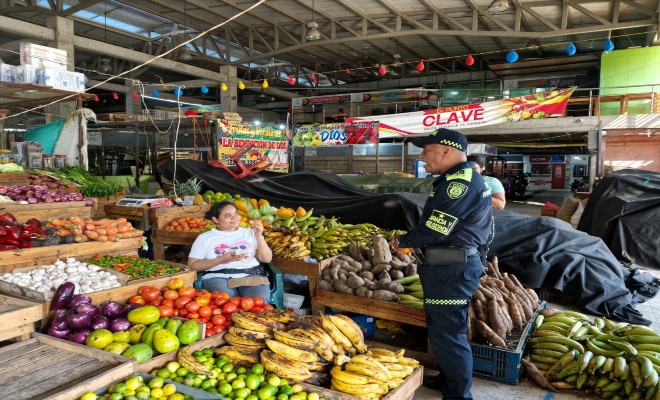un funcionario de la Polic&iacute;a nacional  con una ciudadana brind&aacute;ndoles recomendaciones de seguridad 