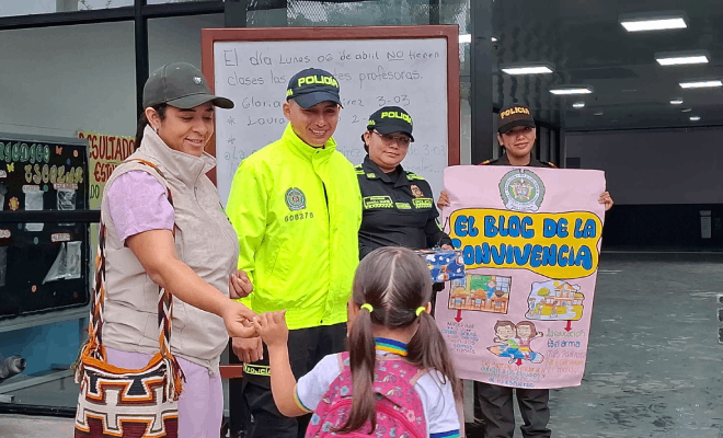 Una persona del ICBF tres policía sosteniendo una cartelera y una niña con uniforme