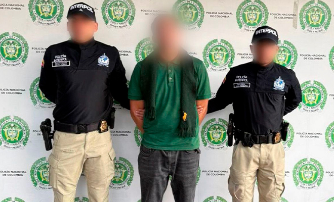 Dos funcionarios de Interpol sostienen a ciudadano francés retenido