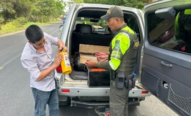 Un funcionario policial de tr&aacute;nsito revisando kit de carretera a un vehiculo junto con un ciudadano