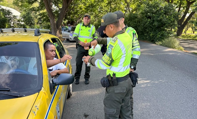 Funcionarios policiales de tr&aacute;nsito entregando caf&eacute; y pan a actores viales