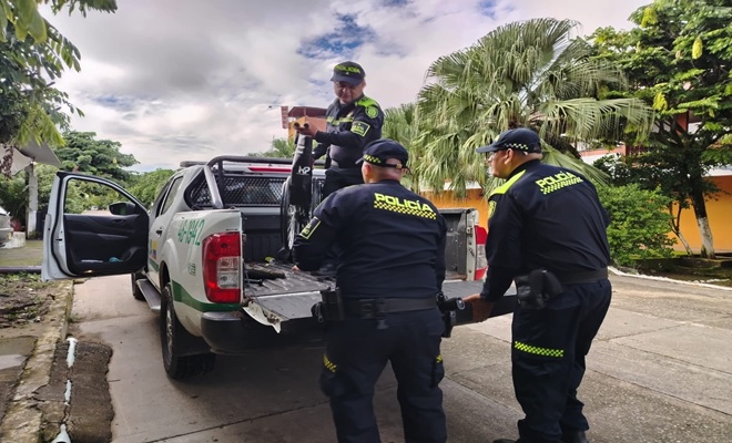 Tres policías bajan silla de un vehículo institucional