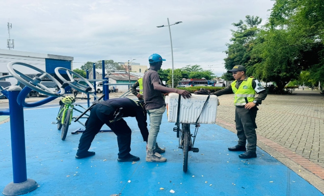 tres uniformados realizando un registro a una persona  en parque principal de la ciudad de Monter&iacute;a