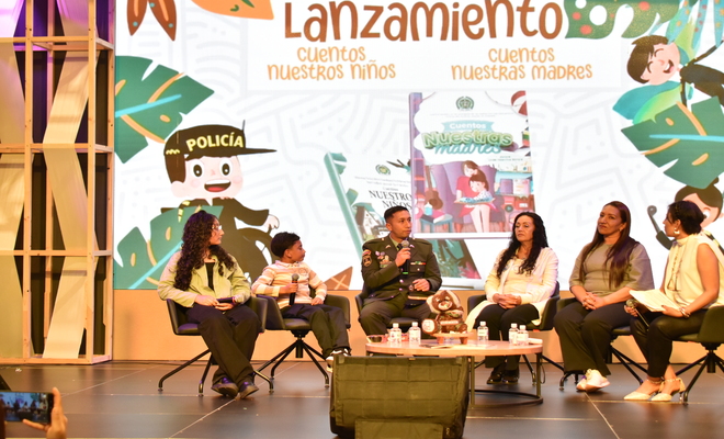 Cuatro mujeres, dos niños y un uniformado, sentados y conversando en la FILBO