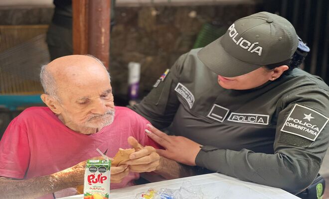 Uniformada de la polic&iacute;a comunitaria acompa&ntilde;a a un adulto mayor durante una actividad de apoyo social.