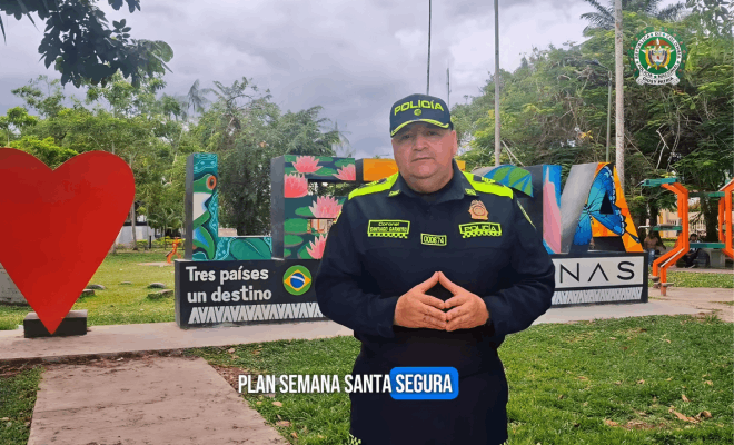 Policía de pie detrás de un muro en Leticia con un corazón dibujado en la pared