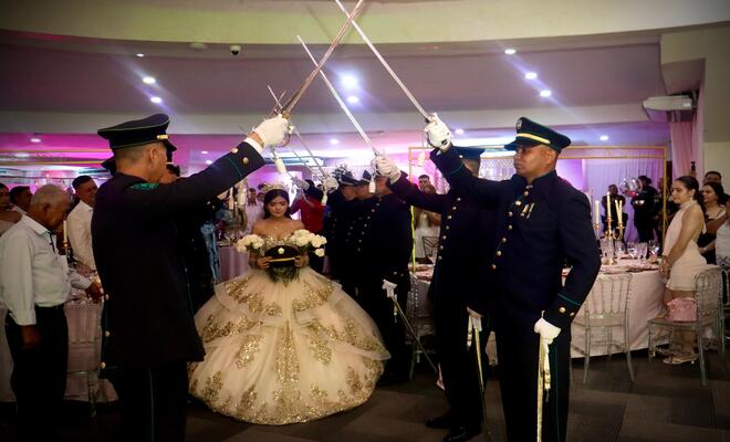 Ingreso de la quincea&ntilde;era bajo arco de honor.