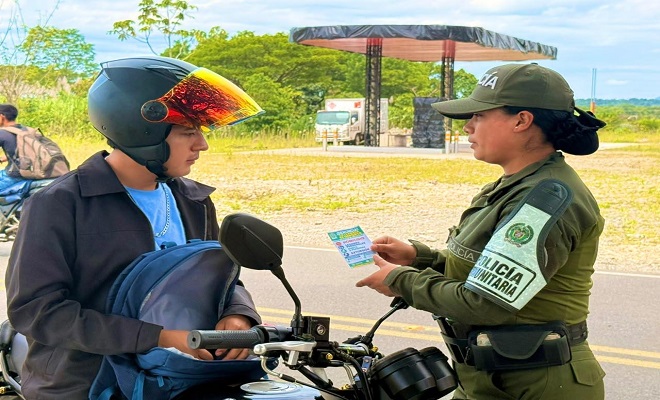 Una mujer policía habla con un motocicleta sensibilizando campaña para la seguridad vial 