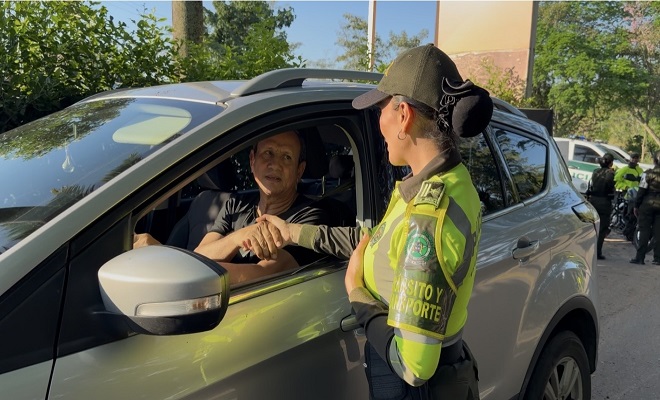 Uniformada de la seccional de tránsito y transporte de la Policía Nacional brindando campaña de prevención y sensibilización a un ciudadano como conductor de vehículo 