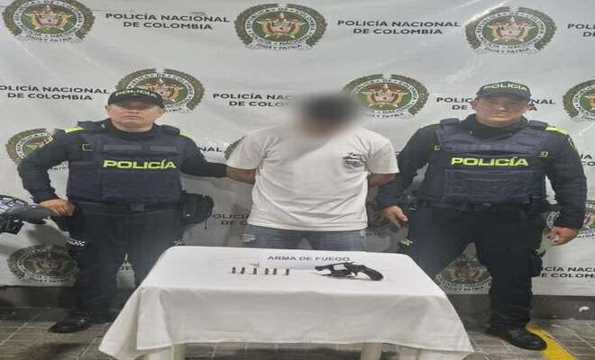 Dos polic&iacute;as junto con una persona capturada