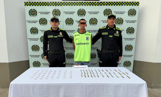 Un ciudadano capturado por el delito de tráfico de estupefacientes y dos funcionarios de la Policía Nacional sujetándolo y brindando seguridad