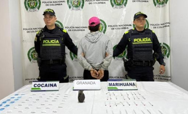 Hombre capturado en medio de dos Policías, en frente elementos incautados.