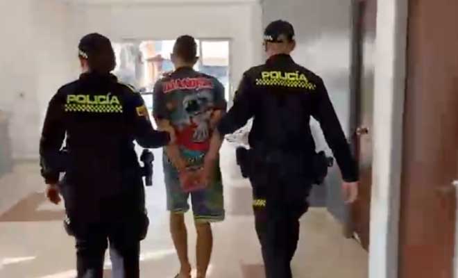 Hombre capturado en medio de dos Policías
