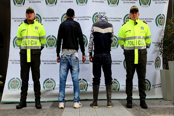 Personas capturadas-policías custodiando