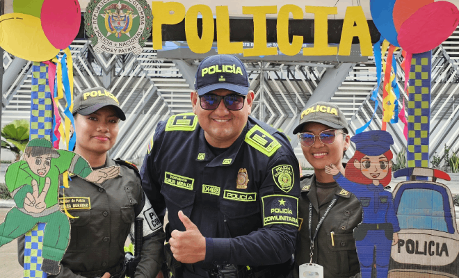  Tres policías posan sonrientes para una foto junto a un letrero que dice Policía