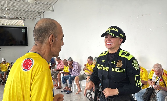Funcionaria de la Policía Nacional bailando con un ciudadano adulto mayor