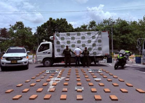 Dos polic&iacute;as al lado de un hombre capturado con clorhidrato de coca&iacute;na