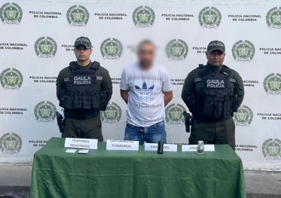 dos policías al lado de un hombre capturado en flagrancia