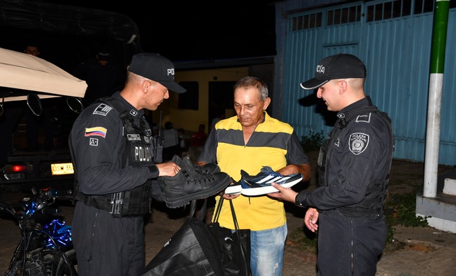 Uniformados hacen entrega de calzado al ciudadano durante una jornada de apoyo y acompañamiento.