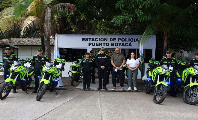 El señor alcalde del municipio de Puerto Boyacá acompañada de una funcionaria de la alcaldía y Ocho Policías junto a las seis motocicletas entregadas